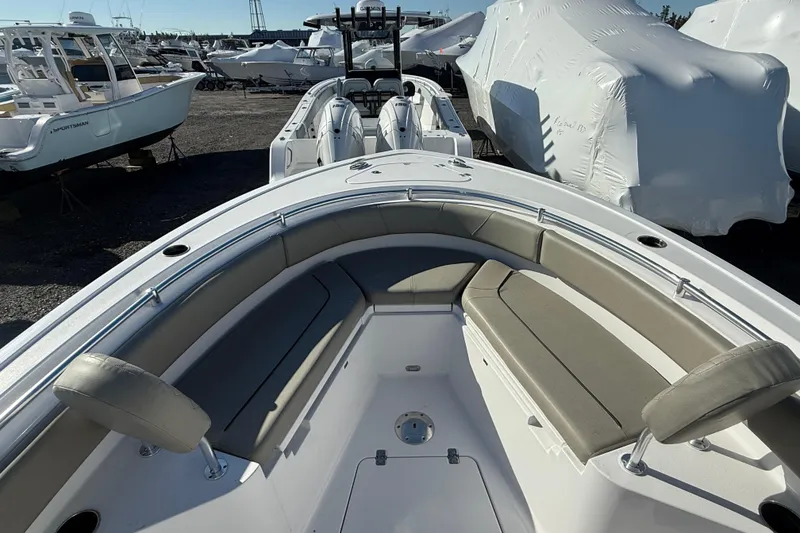 Slide: The Image of 2025 Sportsman Heritage 231 Center Console boat with cushioned seating, docked outdoors. - 5