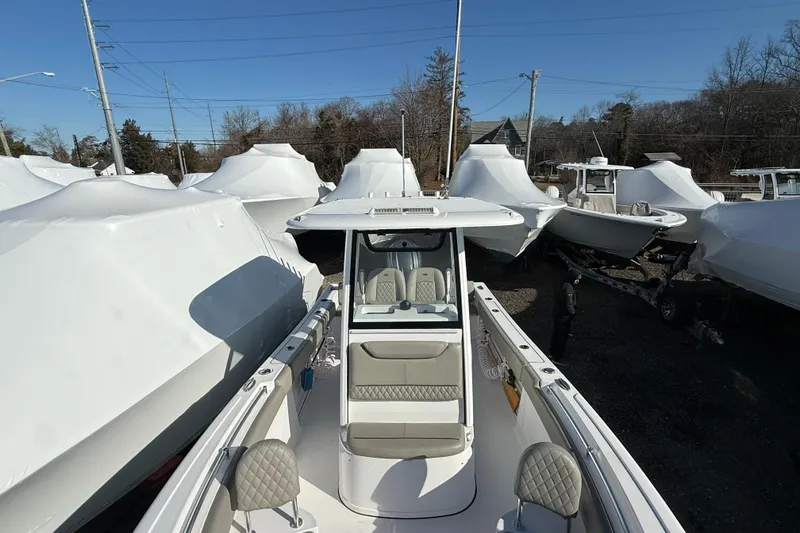 Slide: The Image of 2025 Sportsman Heritage 231 Center Console boat in storage yard, surrounded by covered boats. - 8