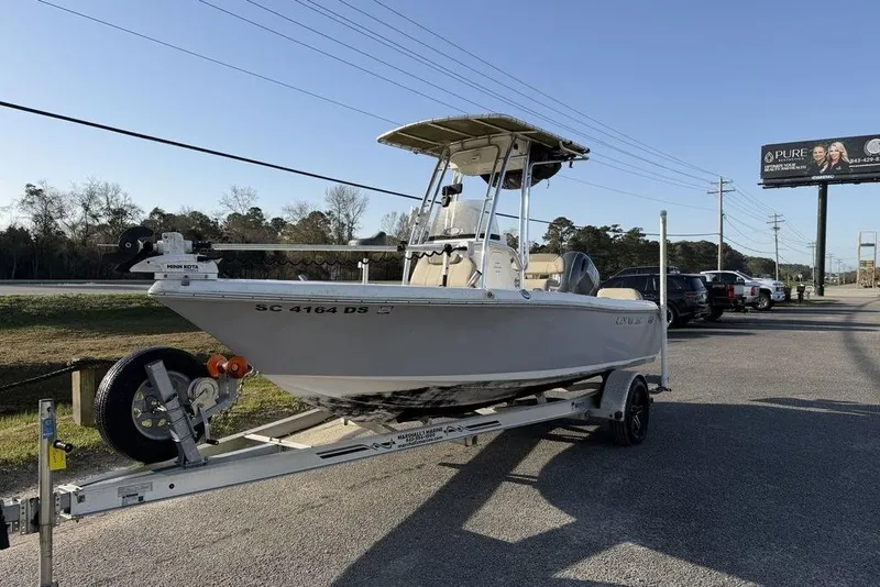 Slide: The Image of 2022 Key West 189 FS boat on trailer, parked near road with cars and billboard. - 1
