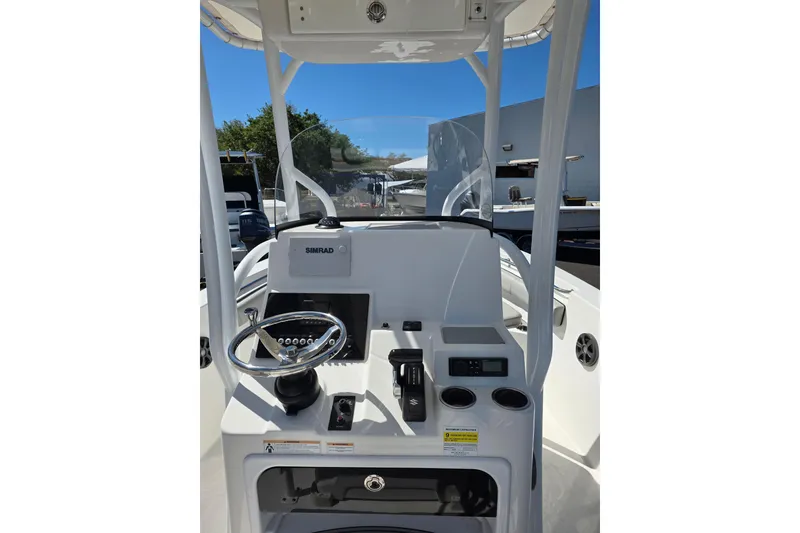 Slide: The Image of 2018 Sea Pro 219 Center Console boat dashboard with steering wheel and Simrad display. - 10