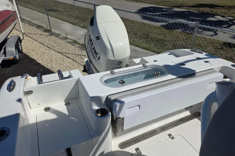 Slide: The Image of 2018 Sea Pro 219 Center Console boat with Suzuki outboard motor, docked near a fence. - 13
