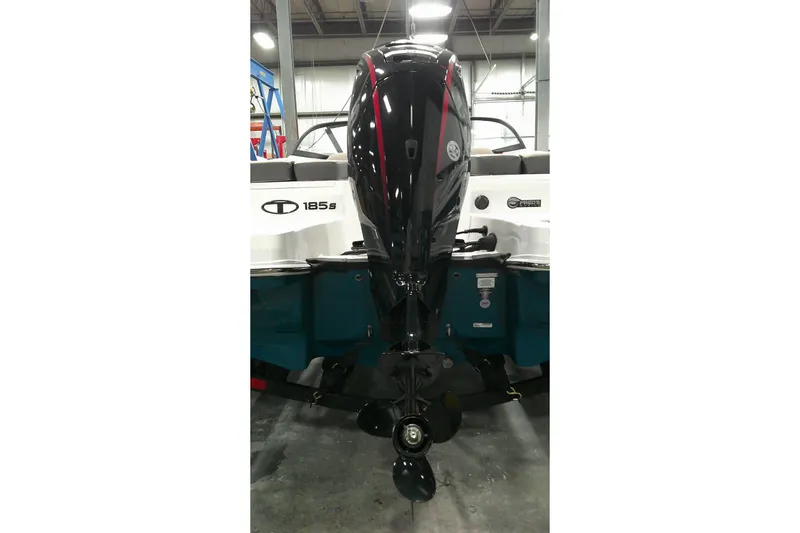 Slide: The Image of 2025 Tahoe 185 S boat with powerful outboard motor in a showroom setting. - 7