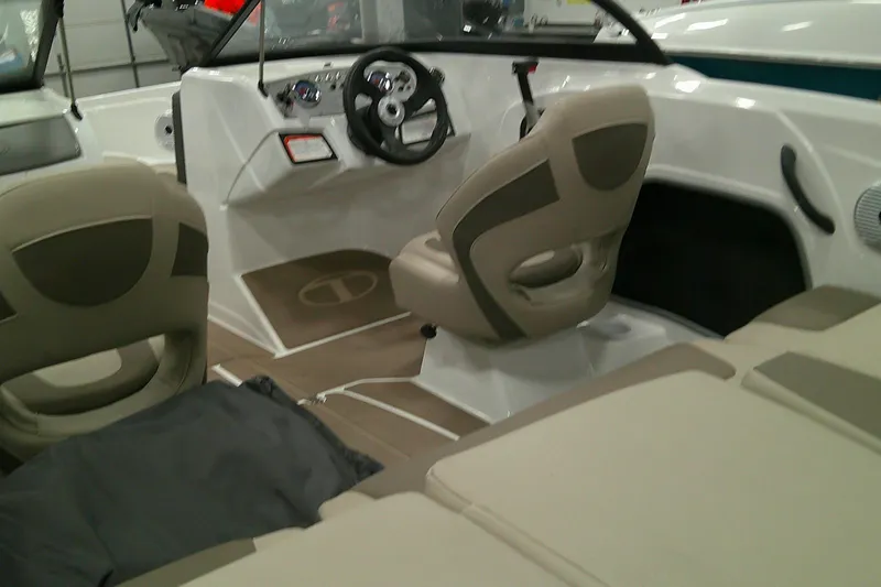 Slide: The Image of Interior of 2025 Tahoe 185 S boat with beige seating and steering console. - 9