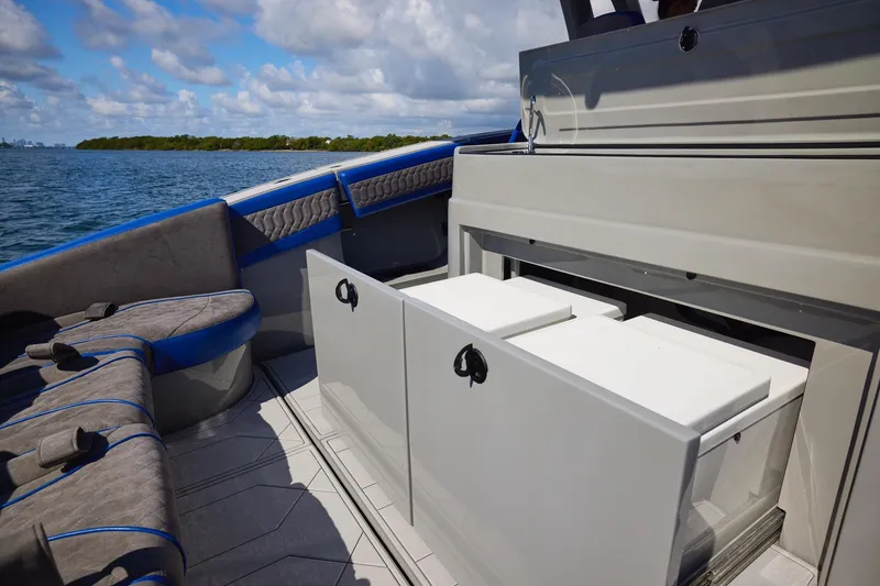 Slide: The Image of 2023 Midnight Express 43 Solstice boat interior with seating and storage on a sunny day. - 17
