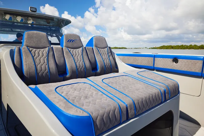 Slide: The Image of Luxurious seating on 2023 Midnight Express 43 Solstice boat, featuring blue and gray upholstery. - 9