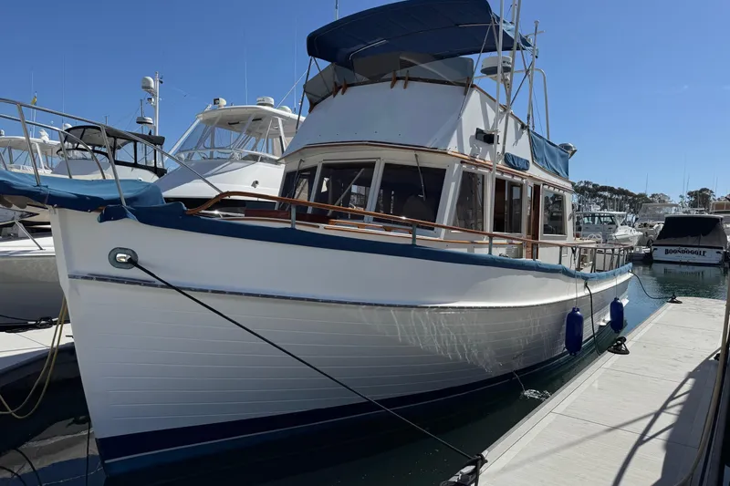 The Image of 1978 Grand Banks 42 Classic yacht docked at marina under clear blue sky. - 0