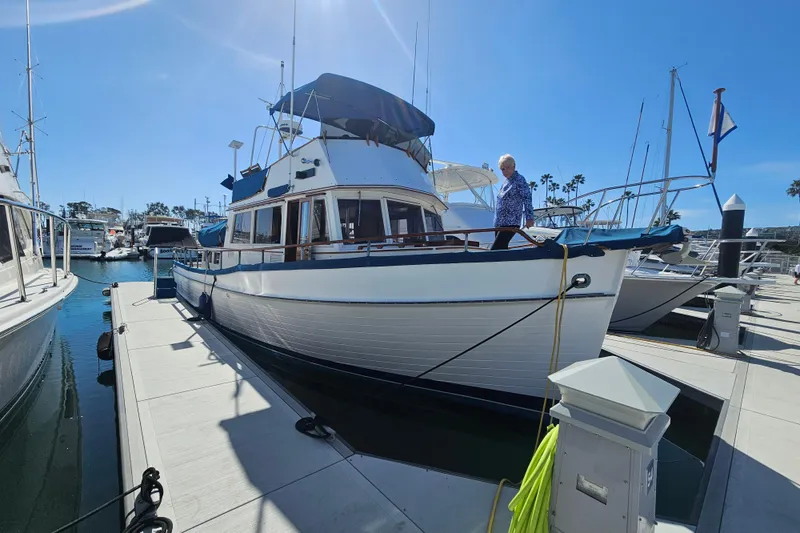 Slide: The Image of 1978 Grand Banks 42 Classic yacht docked at marina under clear blue sky. - 1