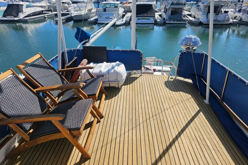 Slide: The Image of Deck of 1978 Grand Banks 42 Classic yacht with chairs and marina view. - 10