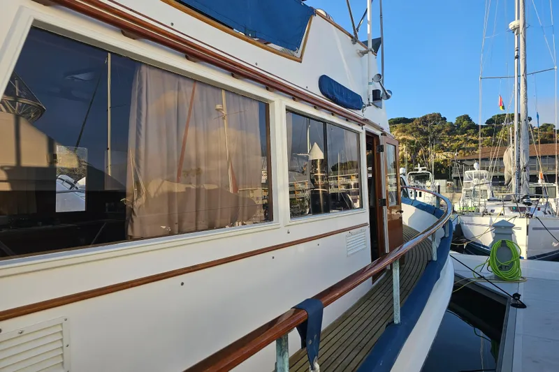 Slide: The Image of 1978 Grand Banks 42 Classic yacht docked at marina, showcasing elegant wooden details. - 11