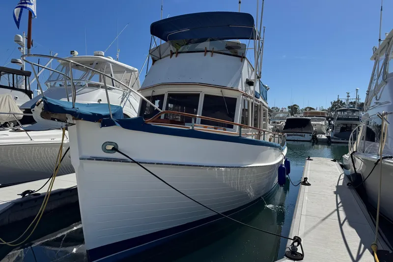 Slide: The Image of 1978 Grand Banks 42 Classic yacht docked in a marina under clear blue skies. - 2