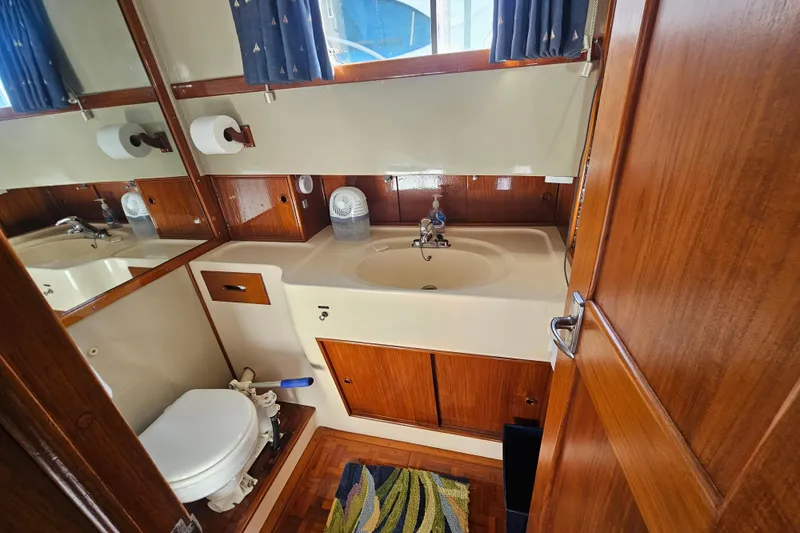 Slide: The Image of 1978 Grand Banks 42 Classic yacht bathroom with wooden cabinetry and nautical decor. - 20