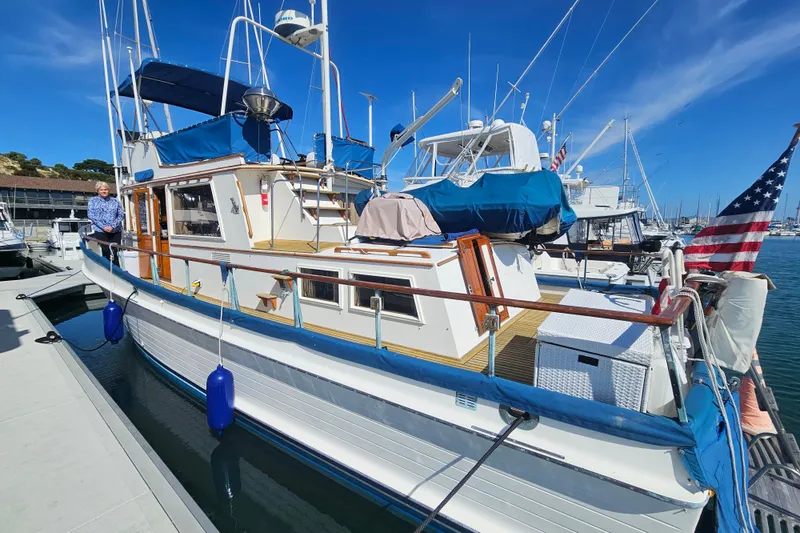 Slide: The Image of 1978 Grand Banks 42 Classic yacht docked at marina with American flag. - 3