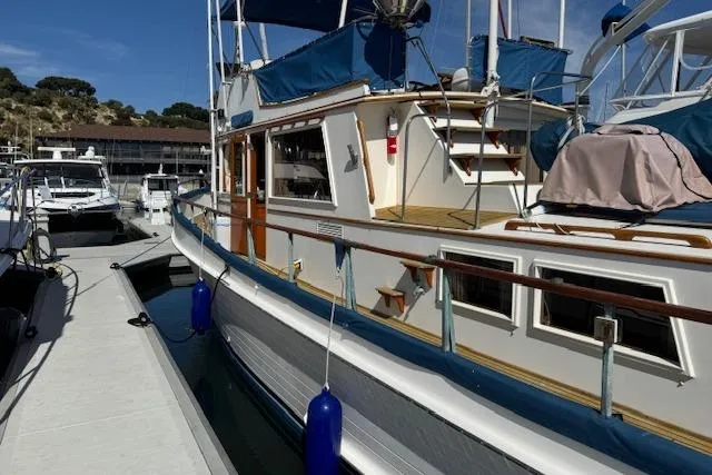 Slide: The Image of 1978 Grand Banks 42 Classic yacht docked, featuring blue canvas covers and wooden accents. - 4