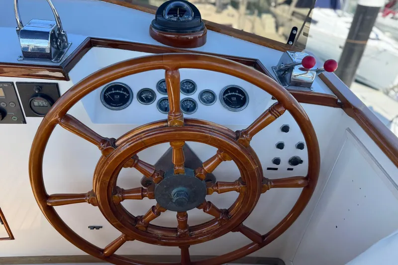 Slide: The Image of Wooden helm of a 1978 Grand Banks 42 Classic yacht with gauges and controls. - 8