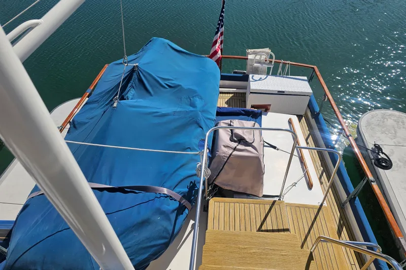 Slide: The Image of 1978 Grand Banks 42 Classic yacht deck with blue cover and American flag. - 9