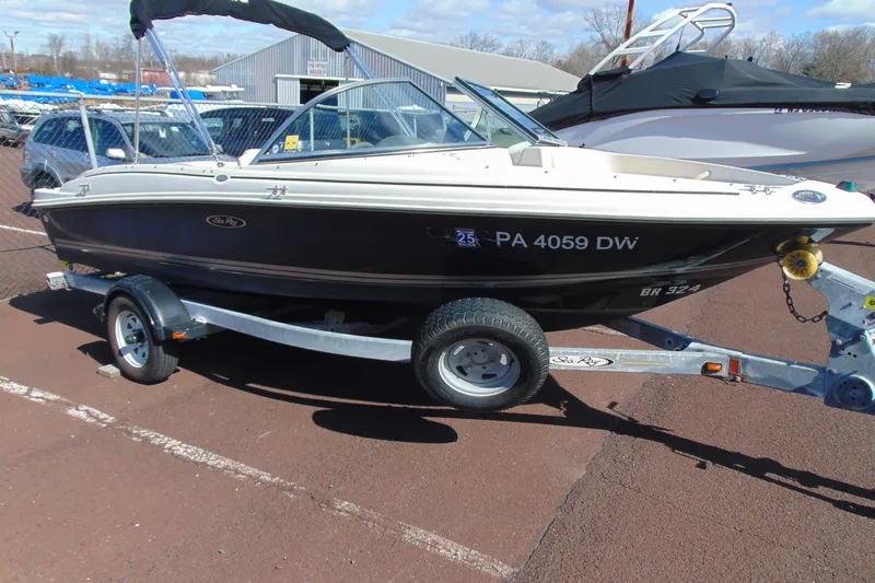 The Image of 2007 Sea Ray 175 Sport boat on trailer, parked outdoors on a sunny day. - 1