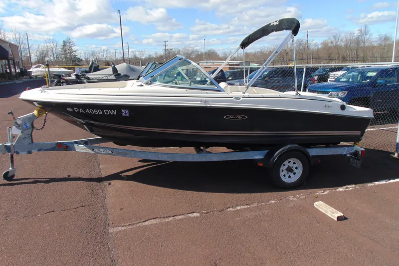 Slide: The Image of 2007 Sea Ray 175 Sport boat on trailer, parked outdoors under a blue sky. - 3