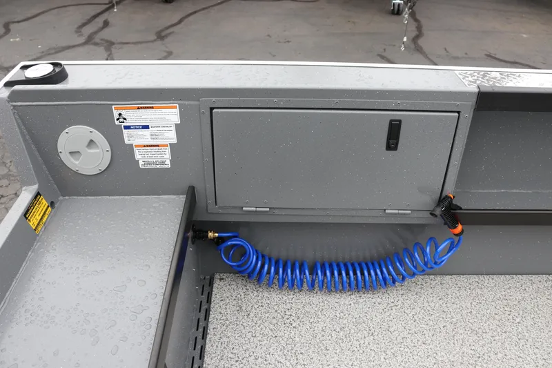 Slide: The Image of 2026 Alumaweld Columbia 23 boat interior with storage compartment and coiled hose. - 12