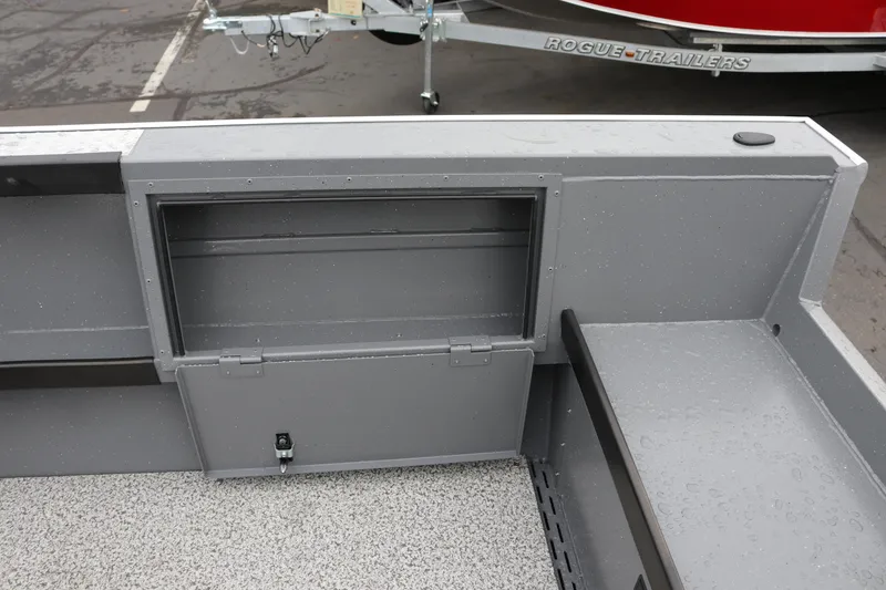 Slide: The Image of 2026 Alumaweld Columbia 23 boat interior with storage compartment and Rogue trailer in background. - 21