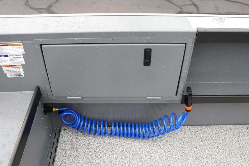 Slide: The Image of 2026 Alumaweld Columbia 23 boat interior with storage compartment and coiled blue hose. - 24