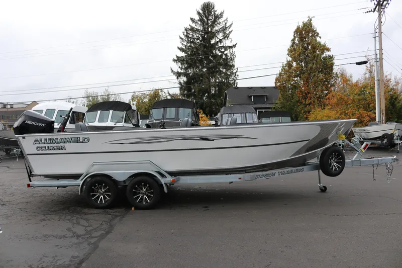 Slide: The Image of 2026 Alumaweld Columbia 23 boat on trailer, parked outdoors with autumn trees. - 27