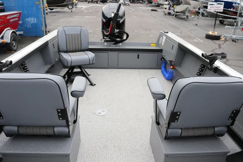 Slide: The Image of 2026 Alumaweld Columbia 23 boat interior with gray seating and motor, parked outdoors. - 4