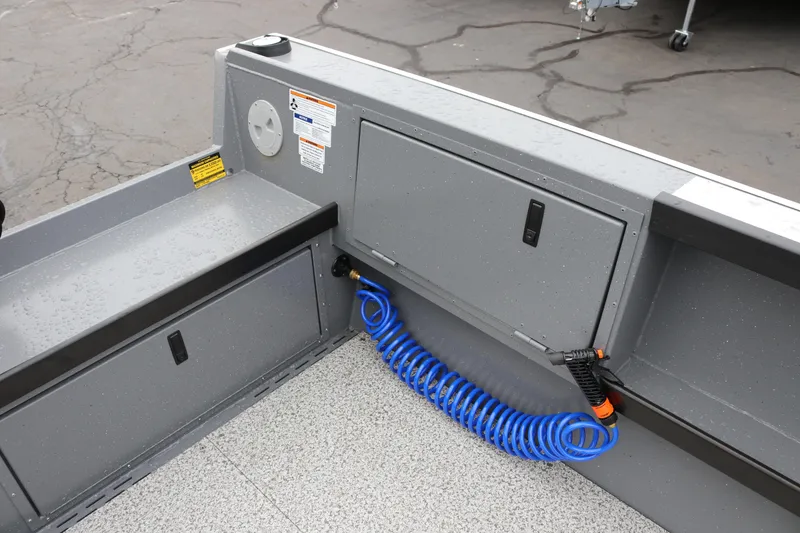Slide: The Image of 2026 Alumaweld Columbia 23 boat interior with storage compartments and coiled blue hose. - 7