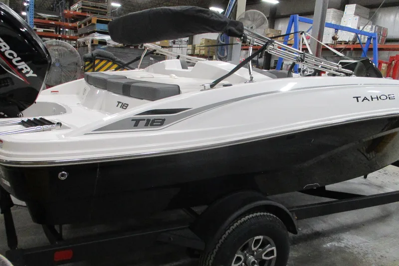 The Image of 2025 Tahoe T18 boat in warehouse, featuring sleek design and Mercury engine. - 0