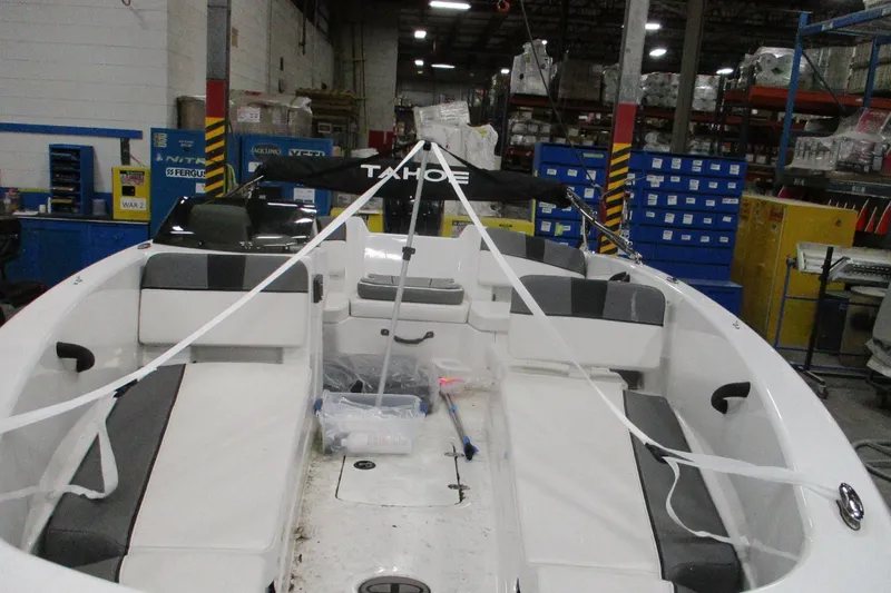 Slide: The Image of 2025 Tahoe T18 boat interior in a warehouse setting, showcasing seating and storage. - 3