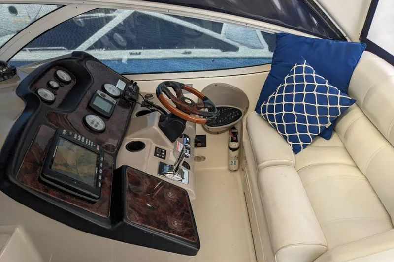 Slide: The Image of Helm of 2003 Cruisers 3970 yacht with navigation instruments and cushioned seating. - 5