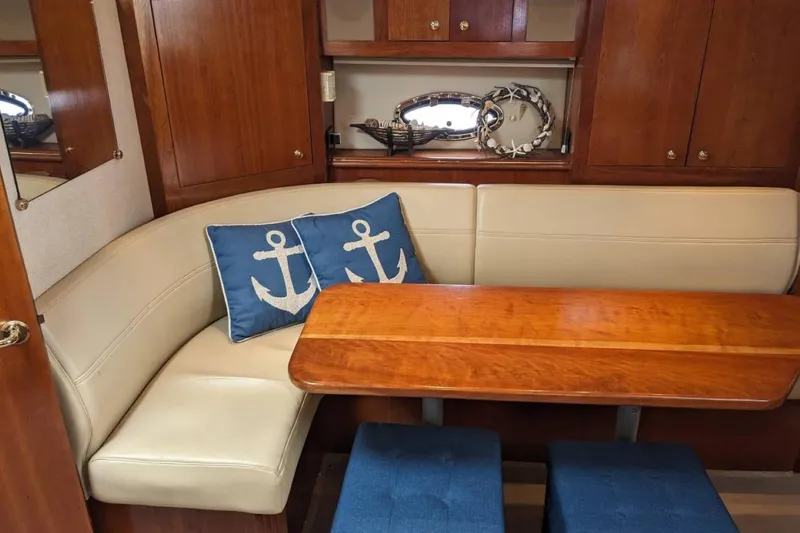 Slide: The Image of Interior of 2003 Cruisers 3970 yacht with wooden table and anchor-themed cushions. - 8