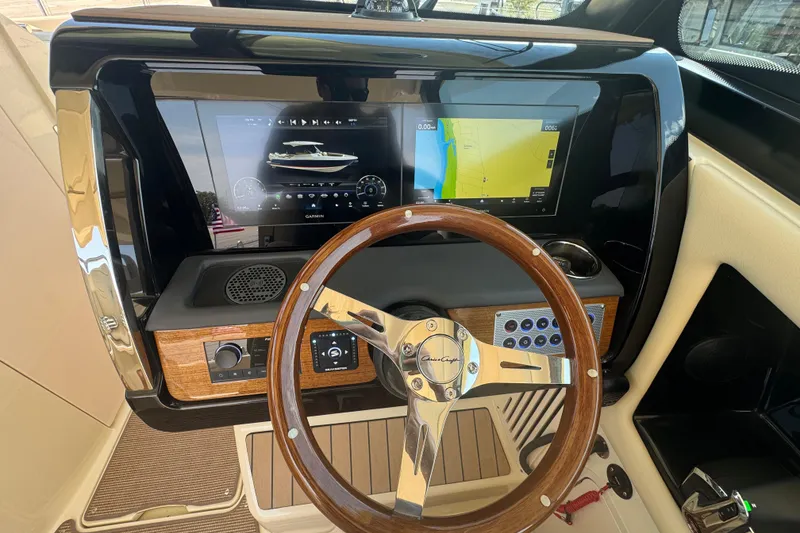 Slide: The Image of 2026 Chris-Craft Calypso 32 dashboard with wooden steering wheel and modern navigation displays. - 10