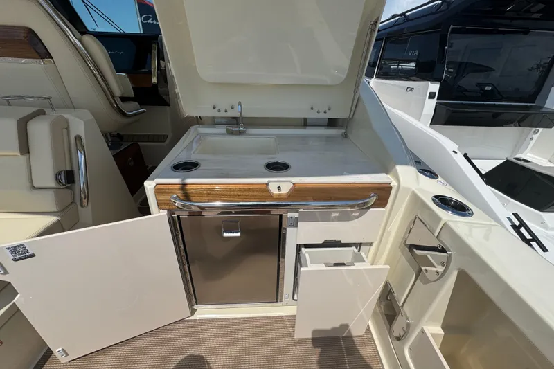 Slide: The Image of 2026 Chris-Craft Calypso 32 boat interior with kitchenette, sink, and storage compartments. - 18