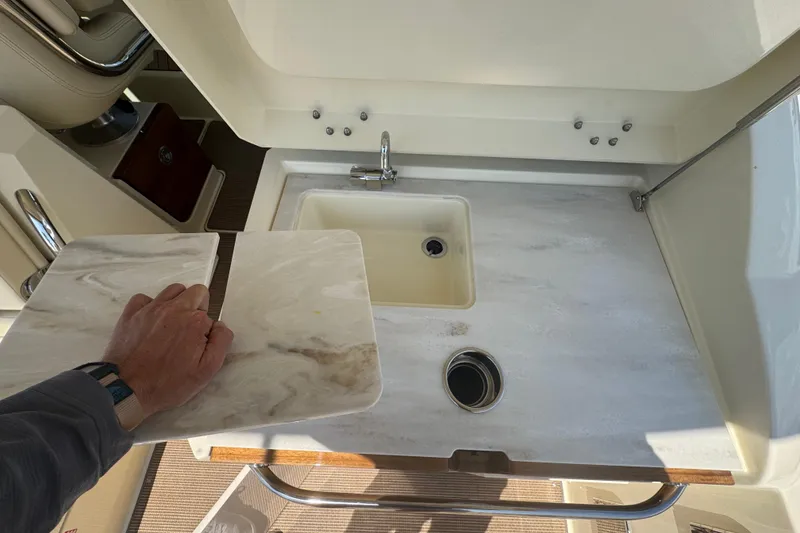 Slide: The Image of 2026 Chris-Craft Calypso 32 boat sink area with marble countertop and faucet. - 19