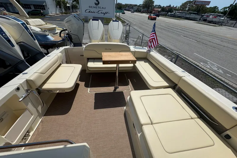 Slide: The Image of 2026 Chris-Craft Calypso 32 boat interior with seating and table, docked near a road. - 23