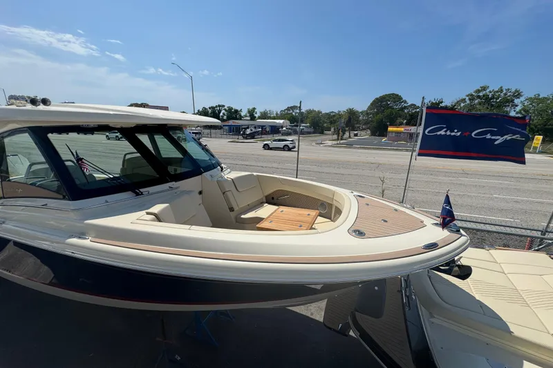 Slide: The Image of 2026 Chris-Craft Calypso 32 boat displayed outdoors with company flag. - 36