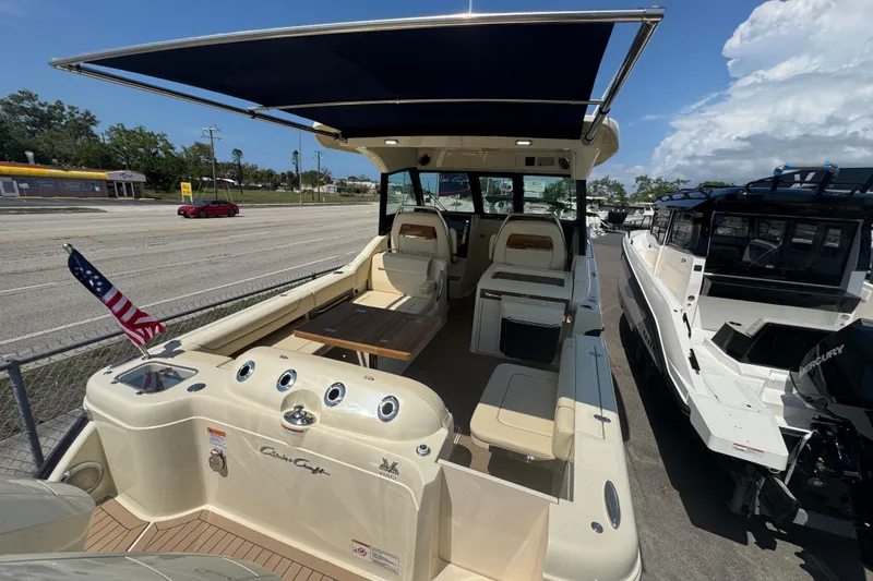 Slide: The Image of 2026 Chris-Craft Calypso 32 boat with seating, canopy, and American flag on display. - 40
