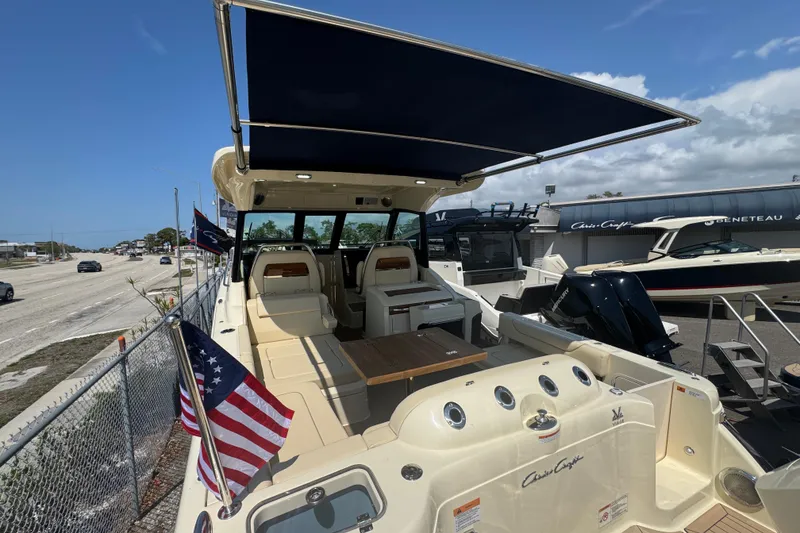 Slide: The Image of 2026 Chris-Craft Calypso 32 boat with canopy and American flag, docked at marina. - 43