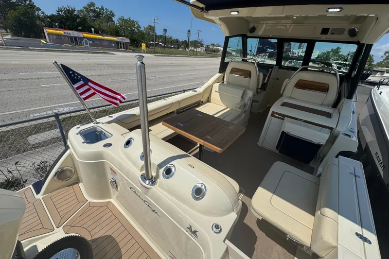 Slide: The Image of 2026 Chris-Craft Calypso 32 boat interior with seating, table, and American flag. - 44