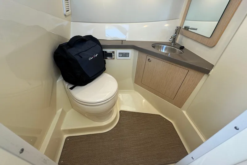 Slide: The Image of 2026 Chris-Craft Calypso 32 boat bathroom with toilet, sink, and storage cabinet. - 53