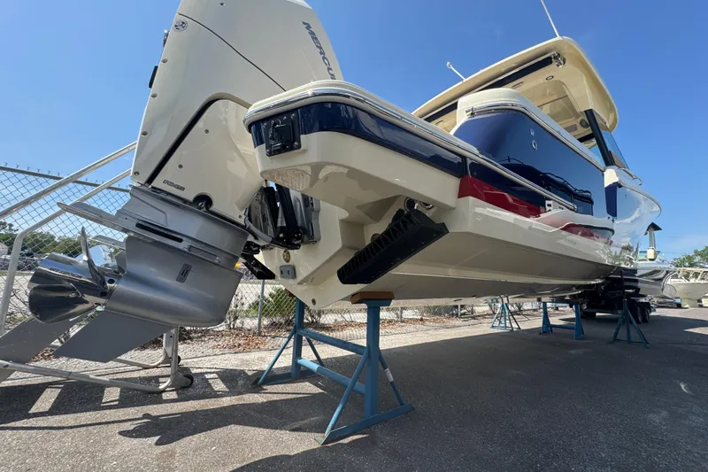 Slide: The Image of 2026 Chris-Craft Calypso 32 boat on stands, showcasing powerful Mercury outboard engine. - 59