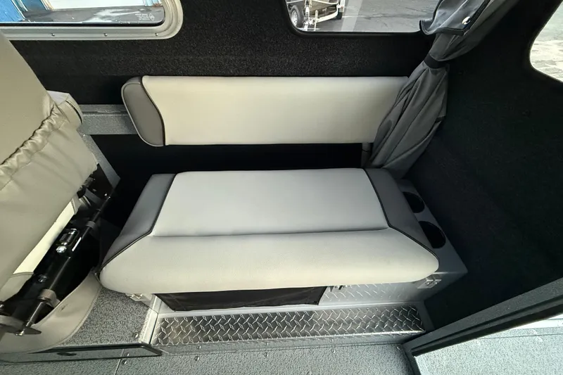 Slide: The Image of Interior seating of 2026 KingFisher 2625 Coastal Express boat, featuring gray upholstery. - 22