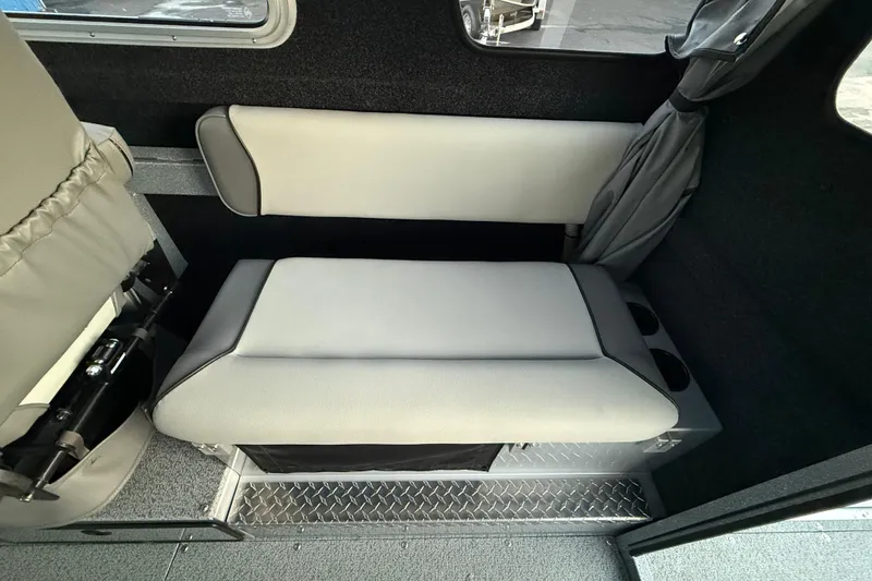 Slide: The Image of Interior seating of 2026 KingFisher 2625 Coastal Express boat, featuring cushioned bench and cup holders. - 23