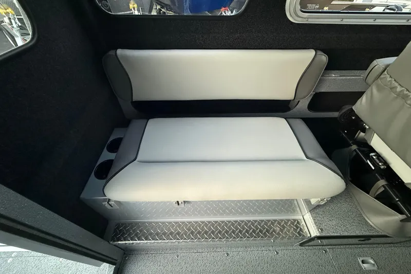 Slide: The Image of 2026 KingFisher 2625 Coastal Express interior seating with cup holders and diamond plate flooring. - 24