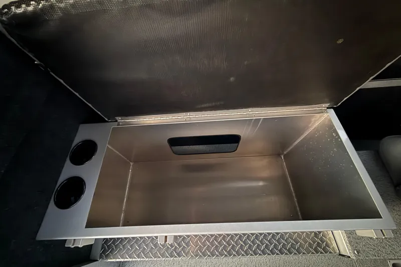 Slide: The Image of Open storage compartment in 2026 KingFisher 2625 Coastal Express boat, featuring dual cup holders. - 26