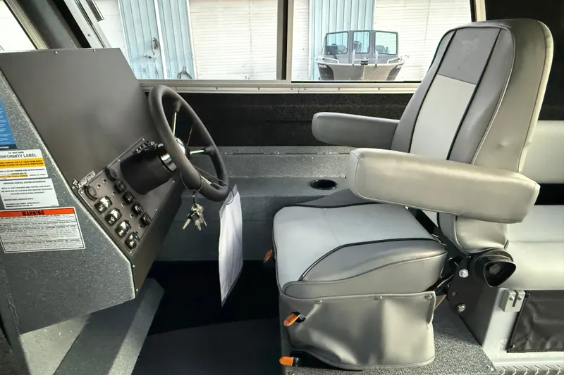 Slide: The Image of Interior of 2026 KingFisher 2625 Coastal Express boat, featuring steering wheel and captain's chair. - 36
