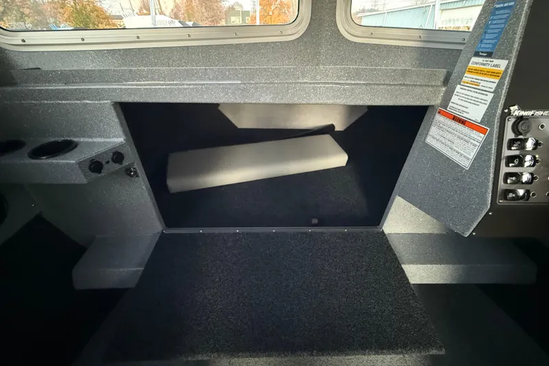 Slide: The Image of Interior of 2026 KingFisher 2625 Coastal Express boat, featuring storage and control panel. - 37