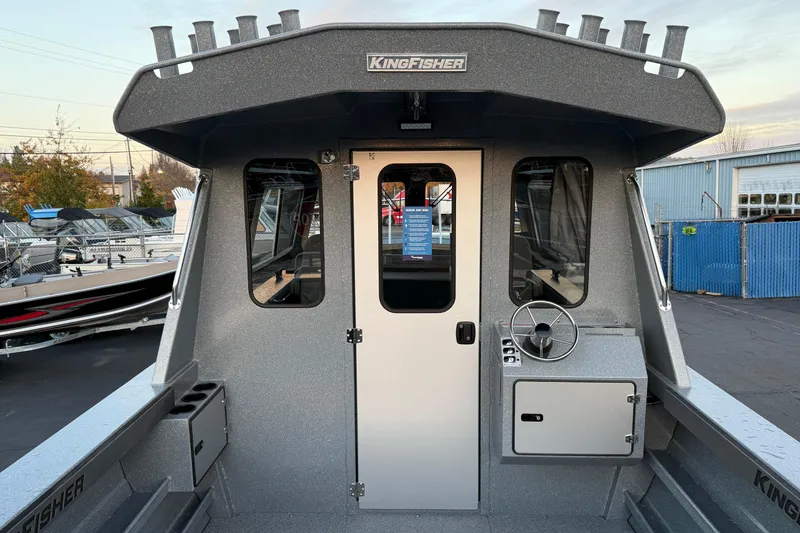 Slide: The Image of 2026 KingFisher 2625 Coastal Express boat exterior with helm and cabin door. - 5