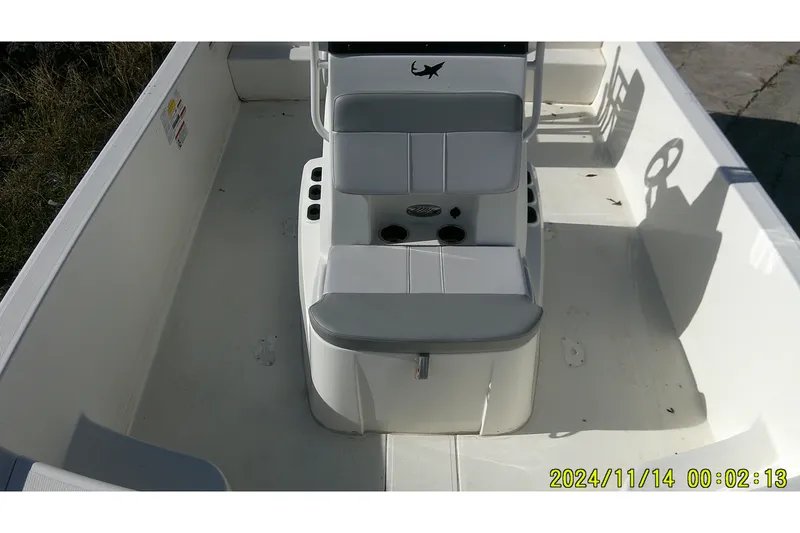 Slide: The Image of 2024 Mako Pro Skiff 19 CC interior with seating and console, photographed in daylight. - 17