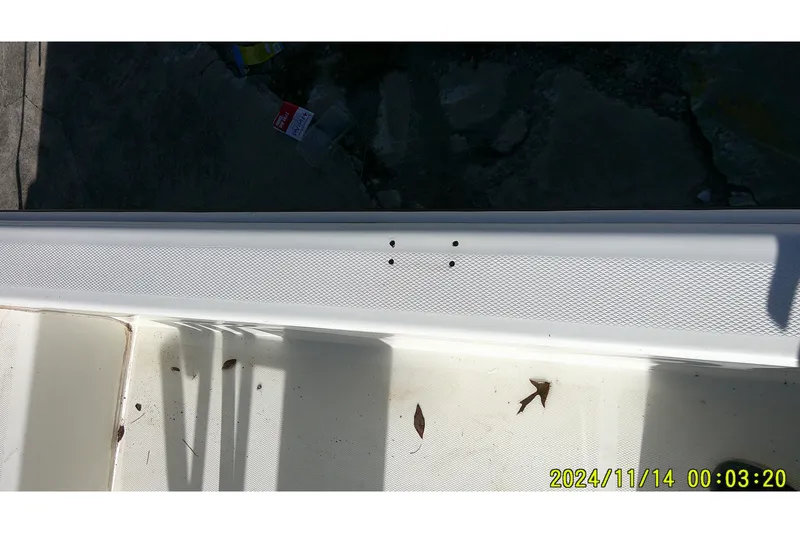 Slide: The Image of 2024 Mako Pro Skiff 19 CC boat deck with leaves and timestamp. - 24